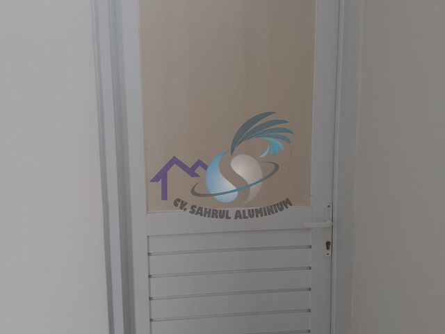 Pintu aluminium putih dengan kisi jalusi ventilasi oleh CV. Sahrul Aluminium