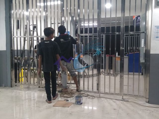 Proses instalasi pintu folding gate stainless steel oleh teknisi CV. Sahrul Aluminium