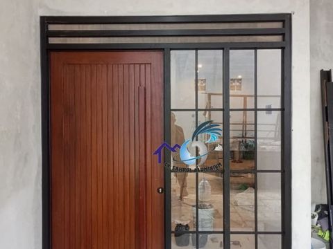 Pintu utama kayu dikombinasikan dengan kusen dan partisi jendela ornamen aluminium hitam